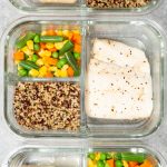 Overhead of three glass meal prep containers. Each is filled with a white fish fillet, mixed vegetables, and quinoa.