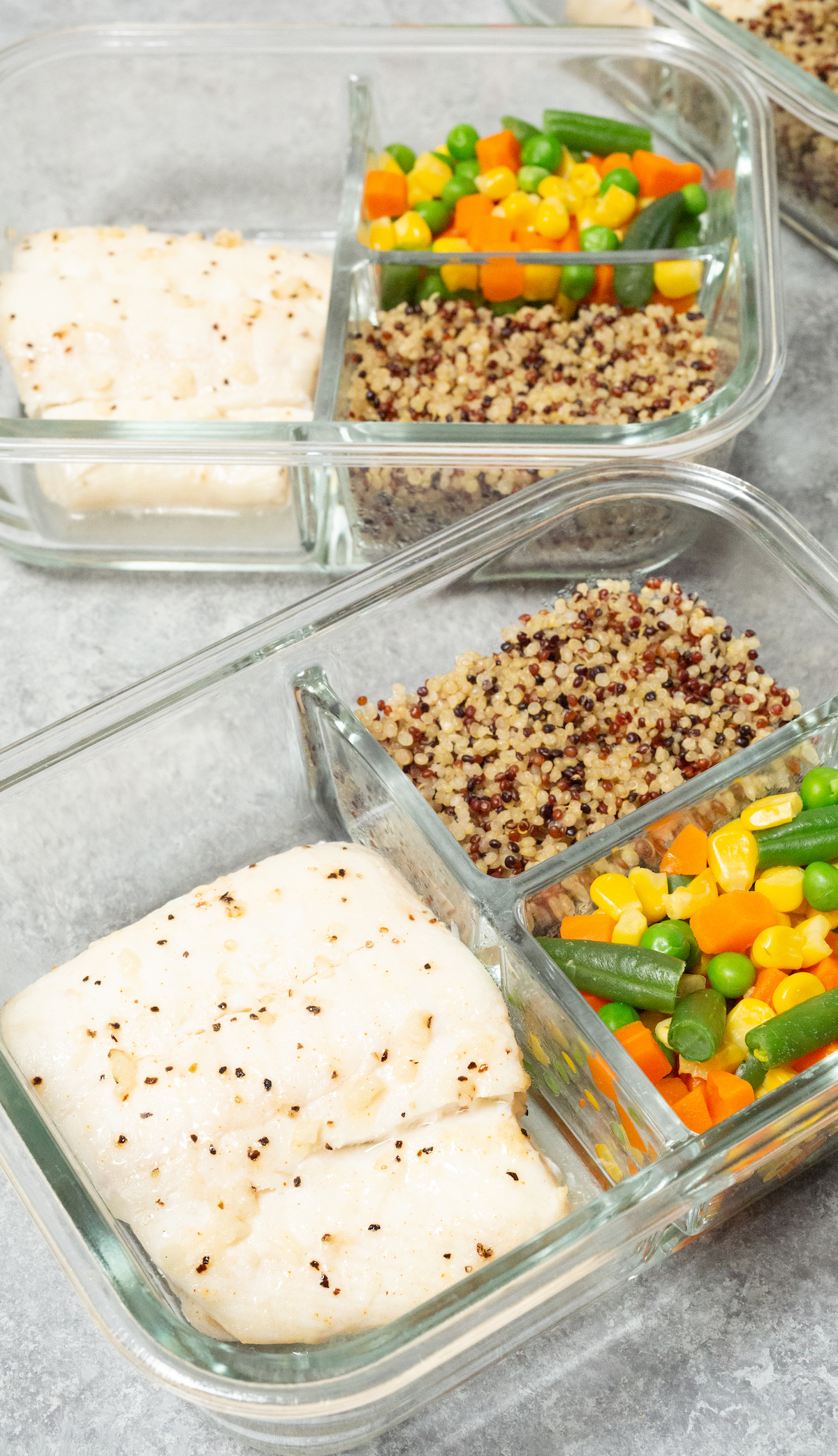 Two glass meal prep containers filled with a white fish fillet, mixed vegetables, and quinoa.